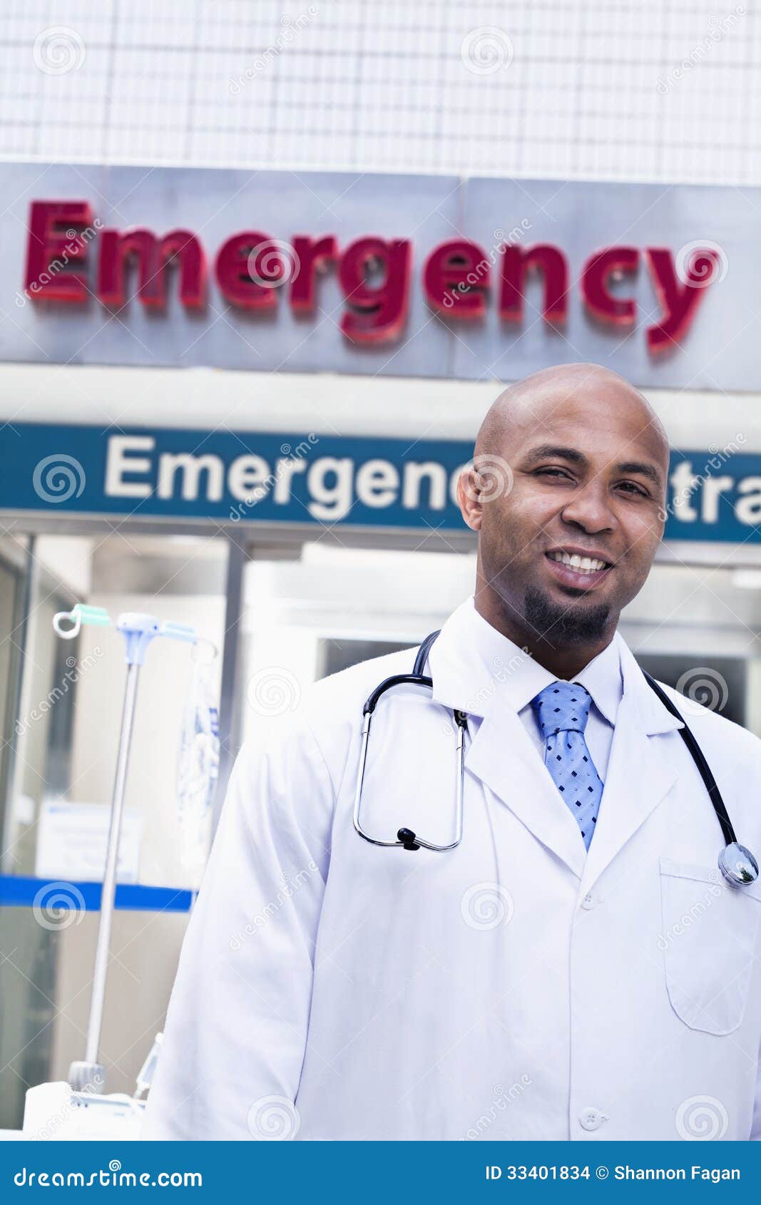 Portret uśmiechnięty doktorski outside szpital, izba pogotowia podpisuje wewnątrz tło
