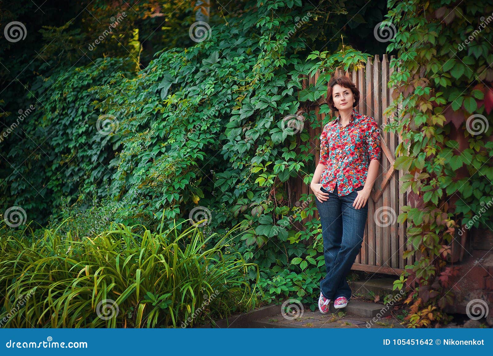 Portret van een meisje in het park. Gang in het de herfstpark met een jong en mooi meisje in jeans