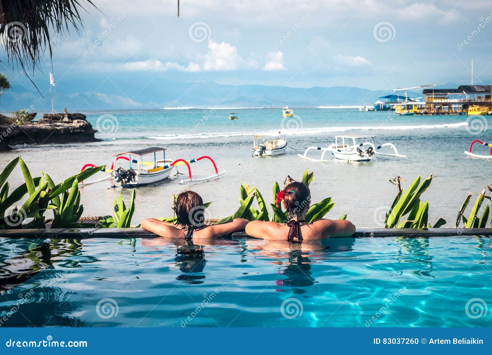 Portret van mooie gelooide vrouw in het zwarte swimwear ontspannen in zwembadkuuroord Hete de zomerdag en heldere zonnig. Portret van mooie gelooide vrouwen in het zwarte swimwear ontspannen in zwembadkuuroord Hete de zomerdag en helder zonnig licht Tropisch eiland Bali, Indonesië