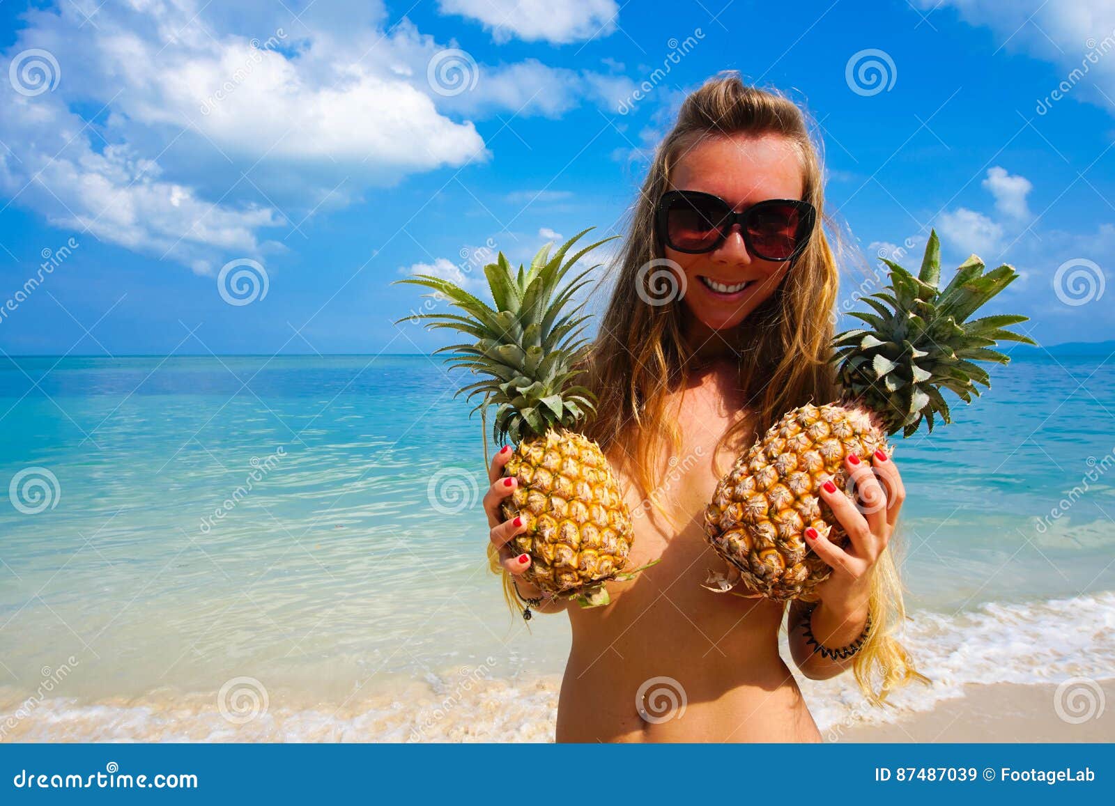 portret-van-sexy-meisje-met-ananassen-met-tropische-overzees-bij-achtergrond-de-stijl-van-de-strandpartij-87487039.jpg