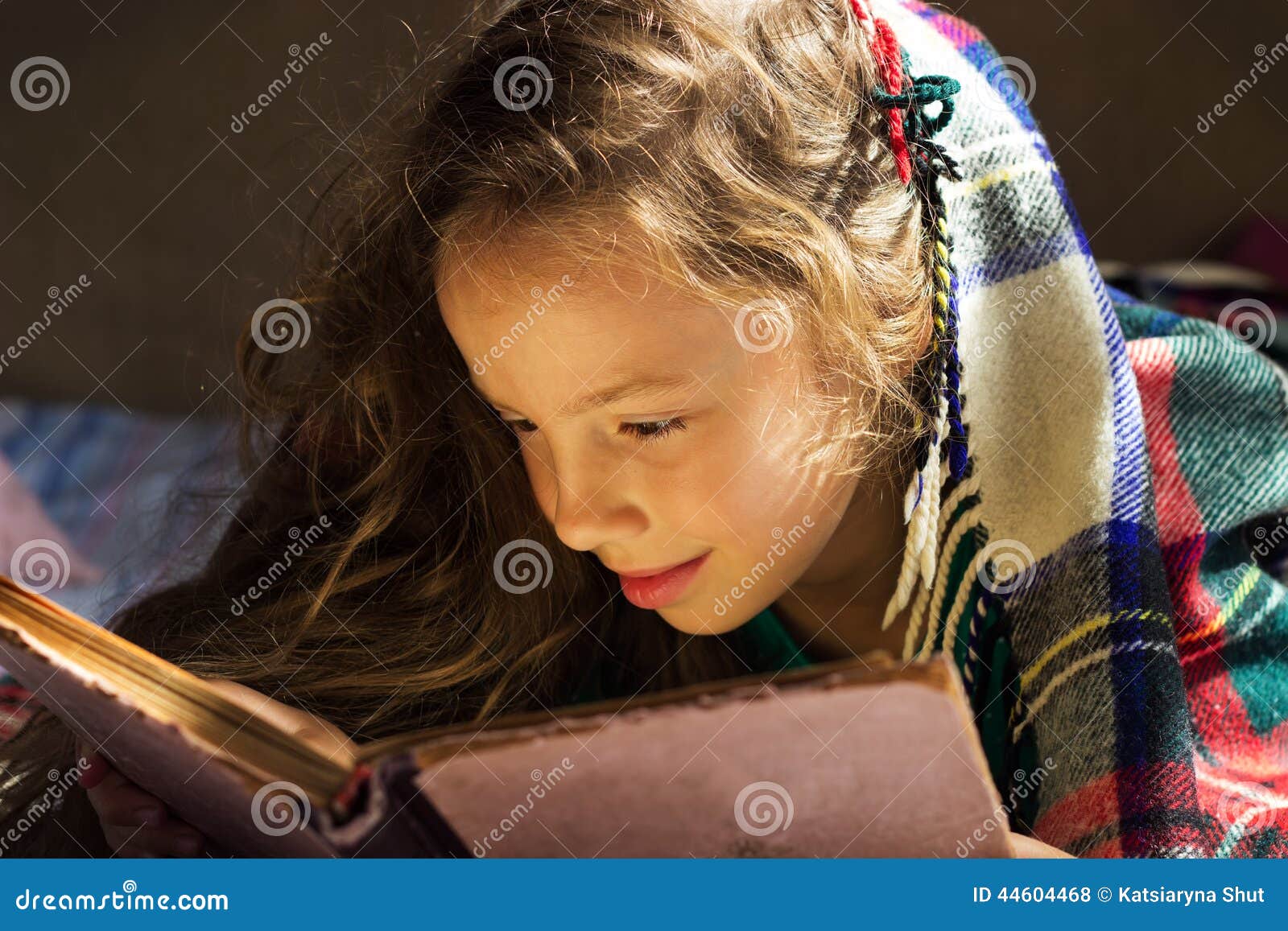 Portret śliczna kędzierzawa szkolna dziewczyna czyta starą książkę przy zimnym dniem