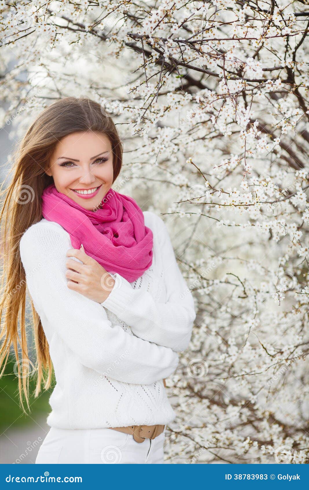 Porträt eines jungen Brunette in einem üppigen Garten. Schönes lächelndes Mädchen über rosa Blütenbaum, draußen Porträt