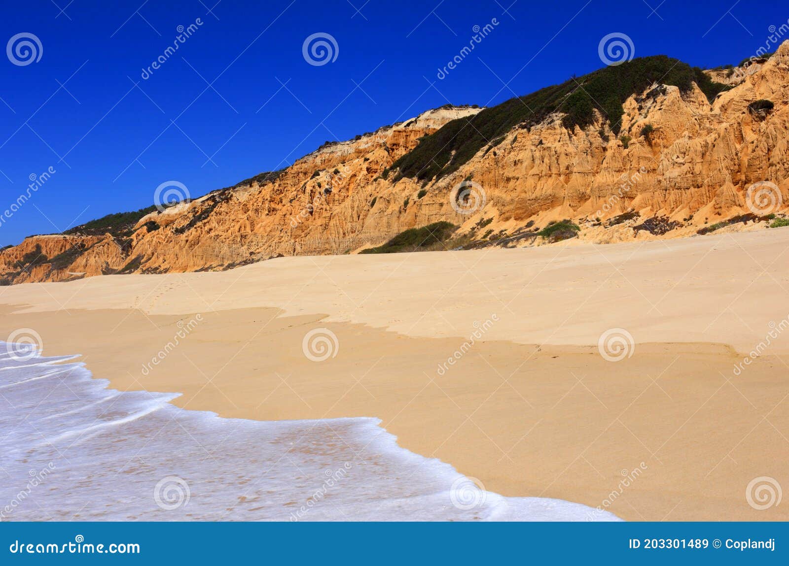 deserted golden sandy beach in olhos de agua, albufeira, algarve, portugal.