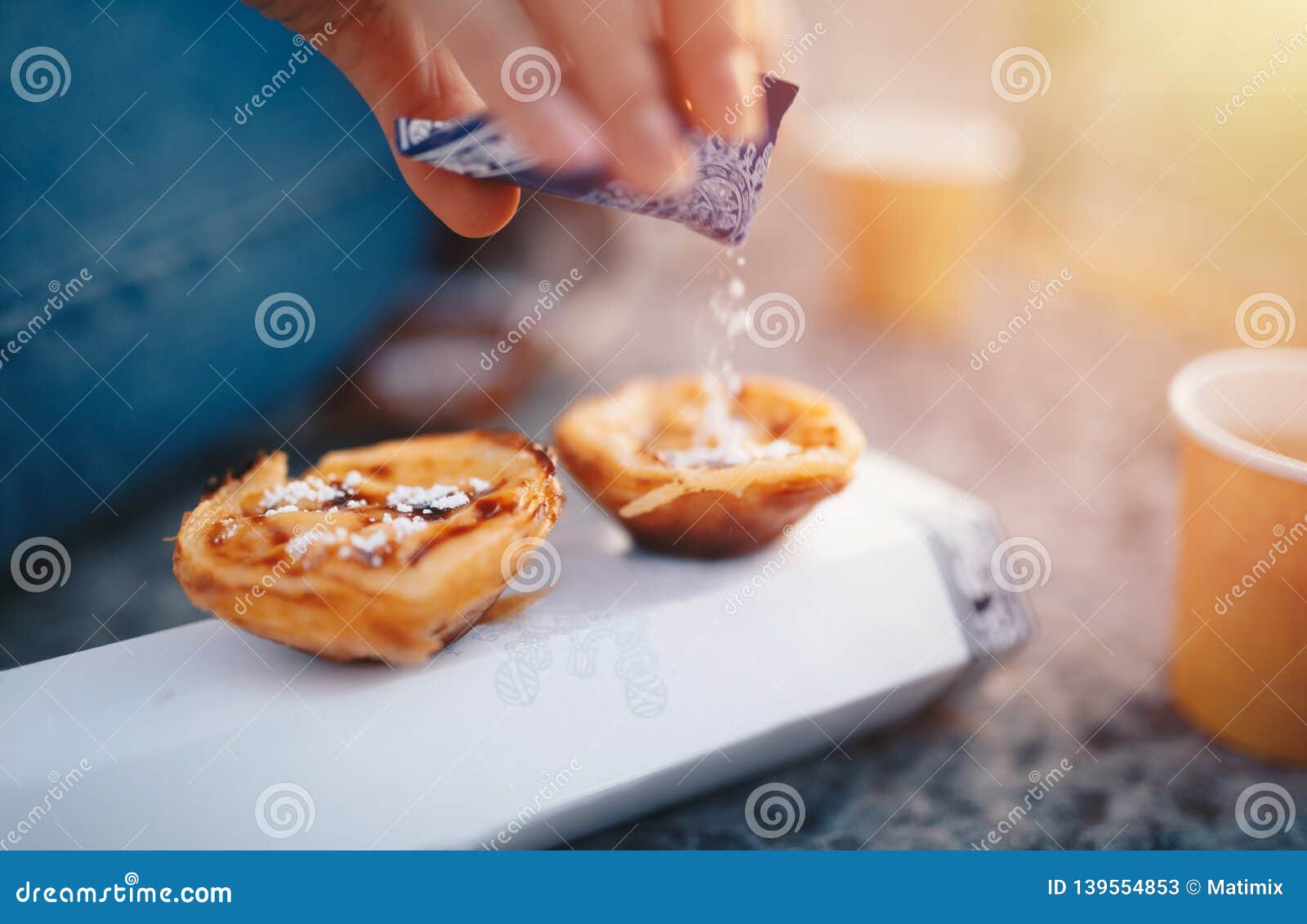 portuguese cake - pasteis de belem or nata. pasteis de belem with sugar powder and cinnamon