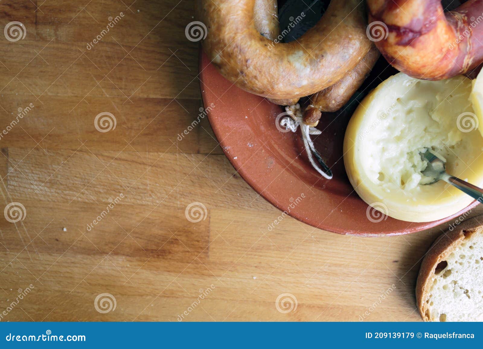 portuguese cheese from azeitao and smoked sausages alheira and chorizo on wooden board. top view with copy space