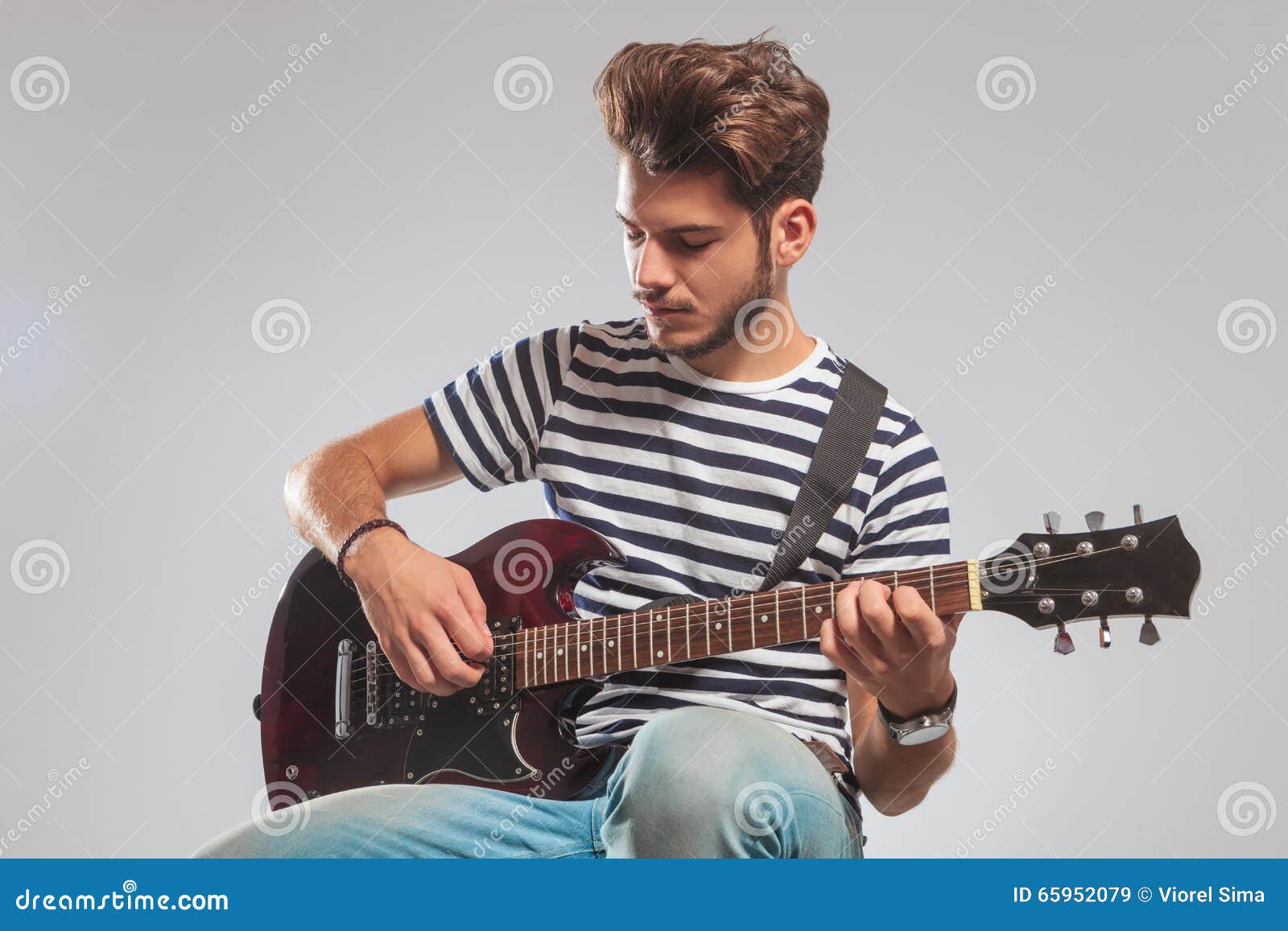 Pose De Guitariste Posée Dans Le Studio Tout En Jouant La Guitare Image  stock - Image du gris, gens: 65952079