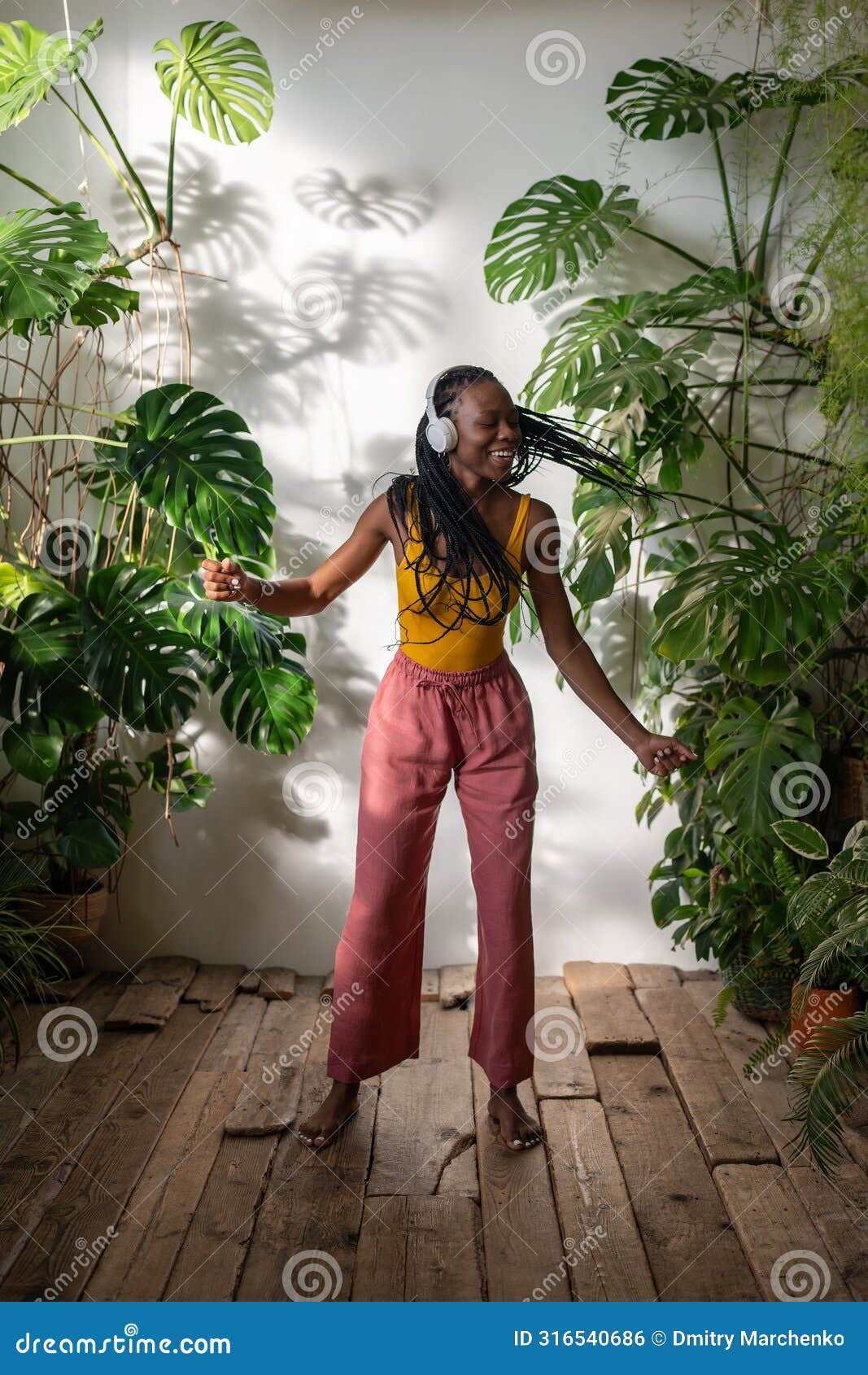 positive black girl dancing barefoot on wooden floor in headphones listening to music enjoy moment.