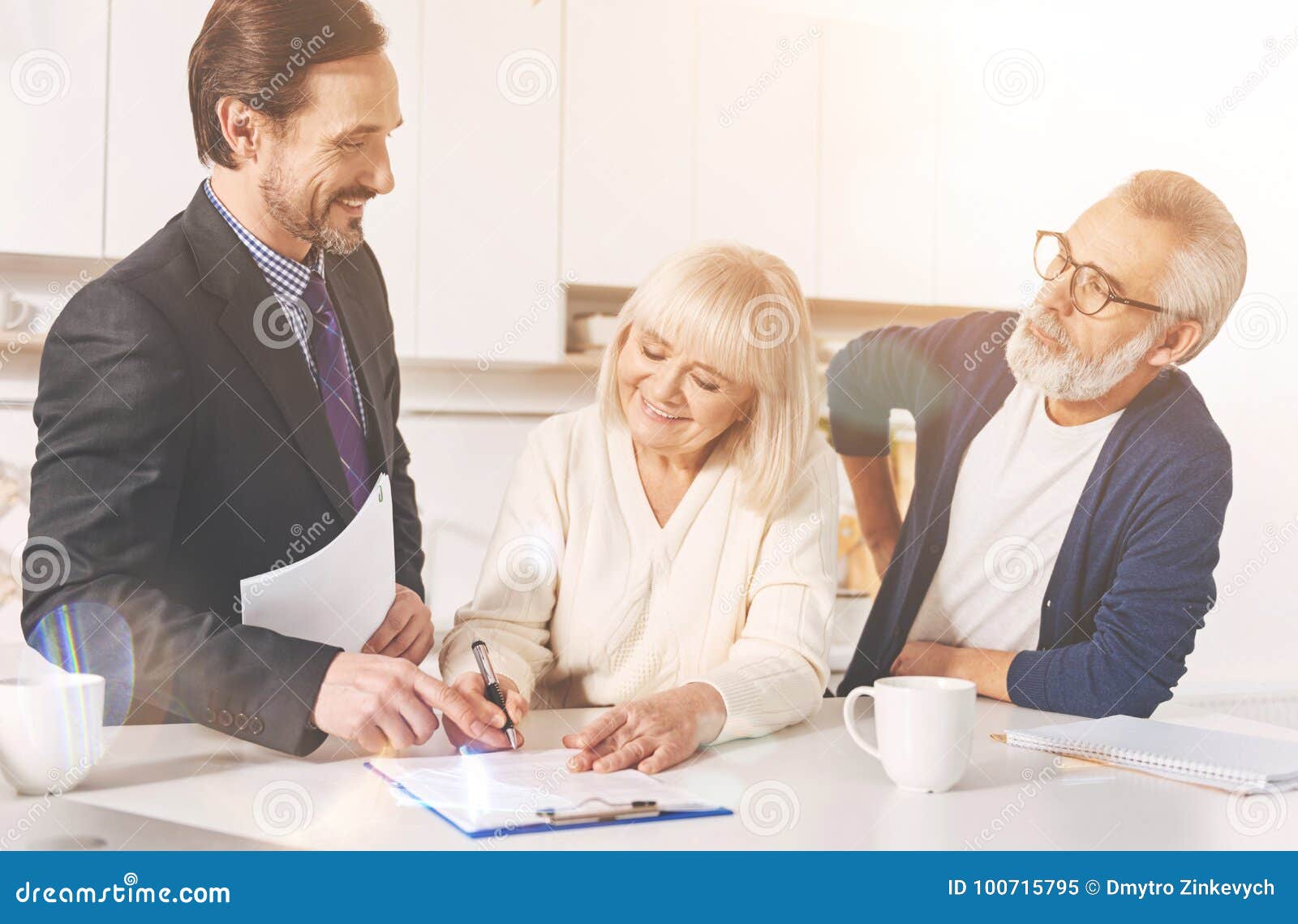positive couple signing papers with insurance agent