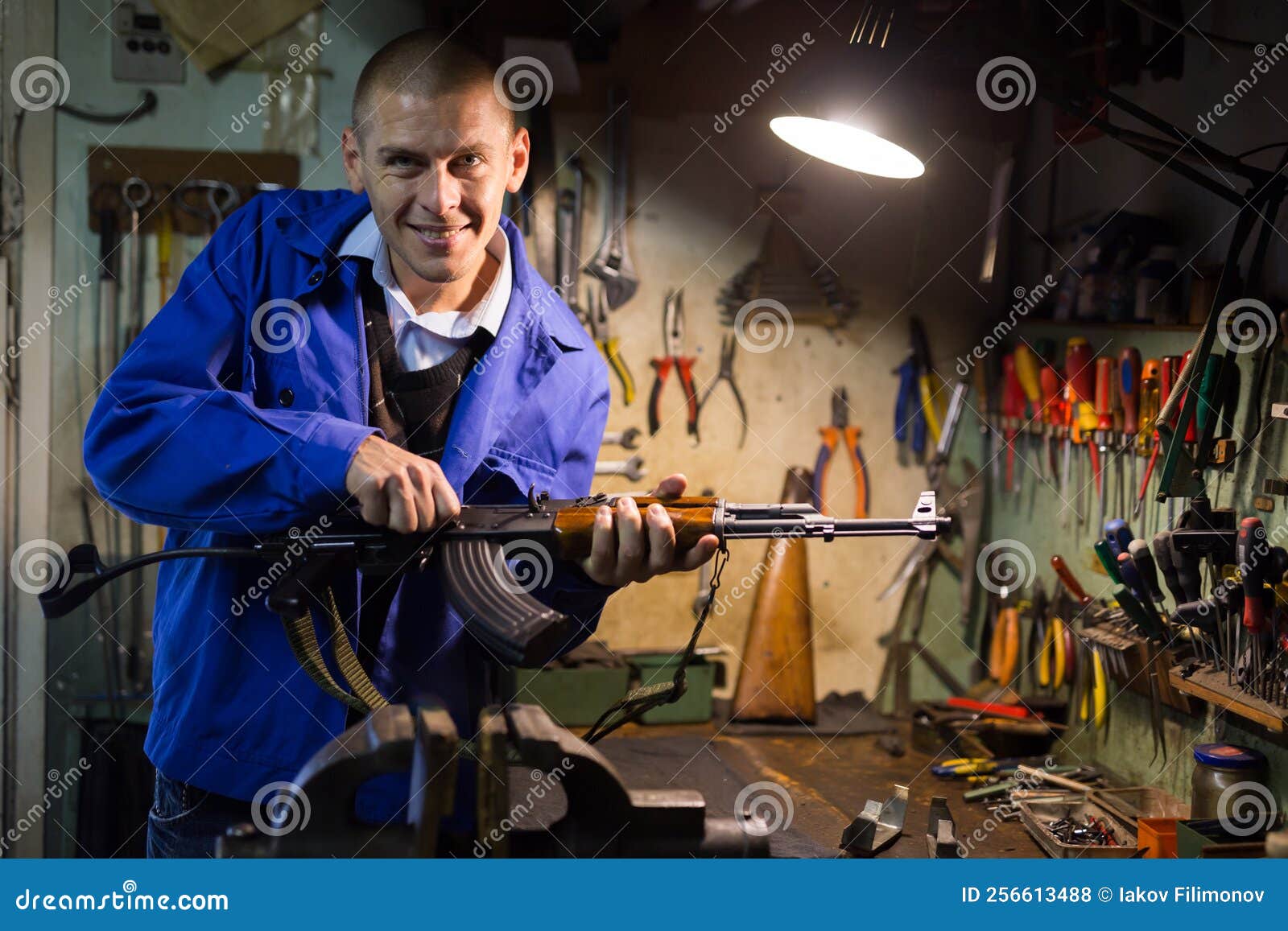 Smiling Gunsmith Disassembling Kalashnikov Assault Rifle in Weapons