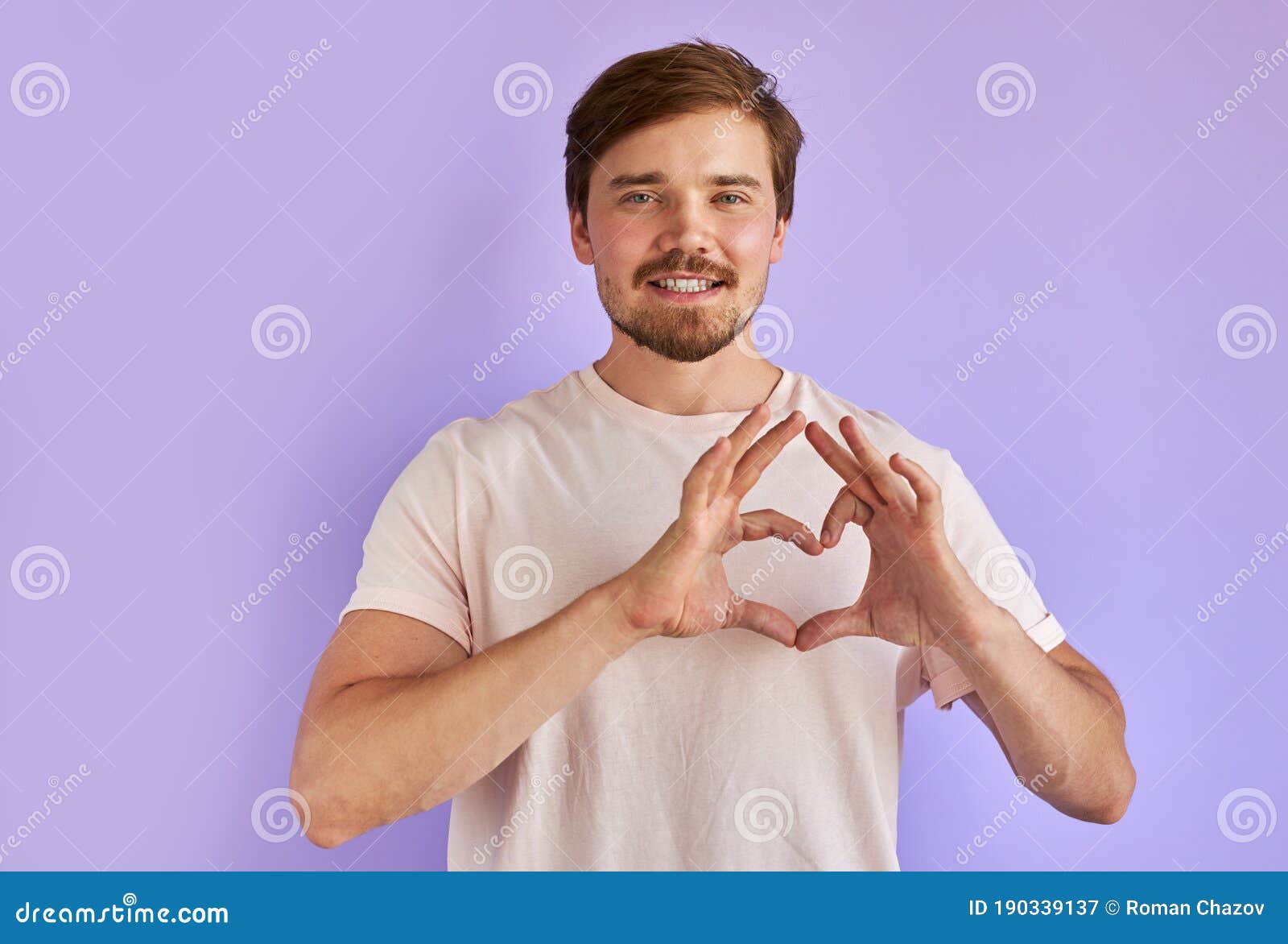 positive guy shows love gesture at camera