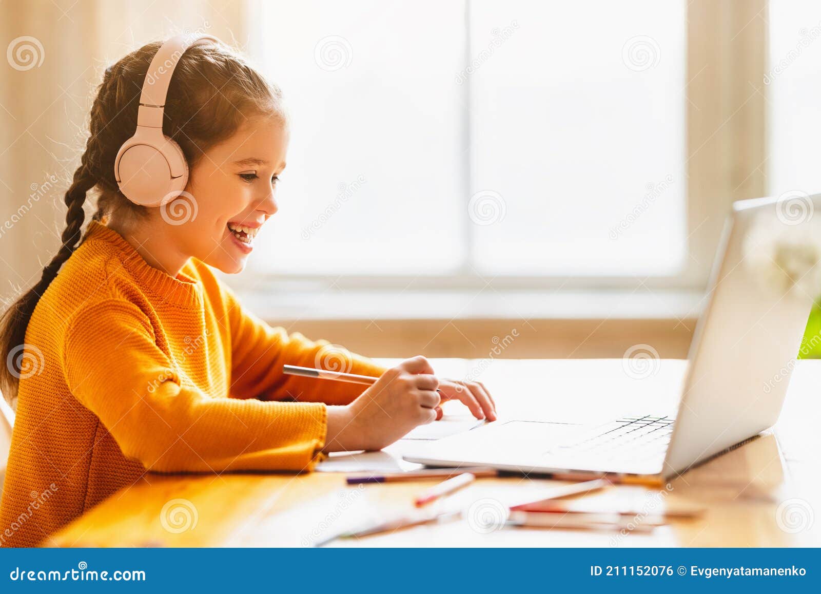 happy girl having online lesson via laptop at home