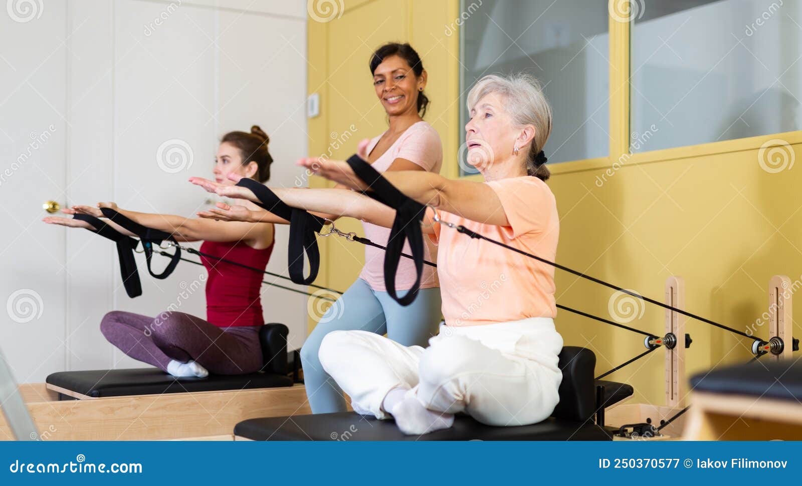senior woman doing stretching exercises on pilates reformer