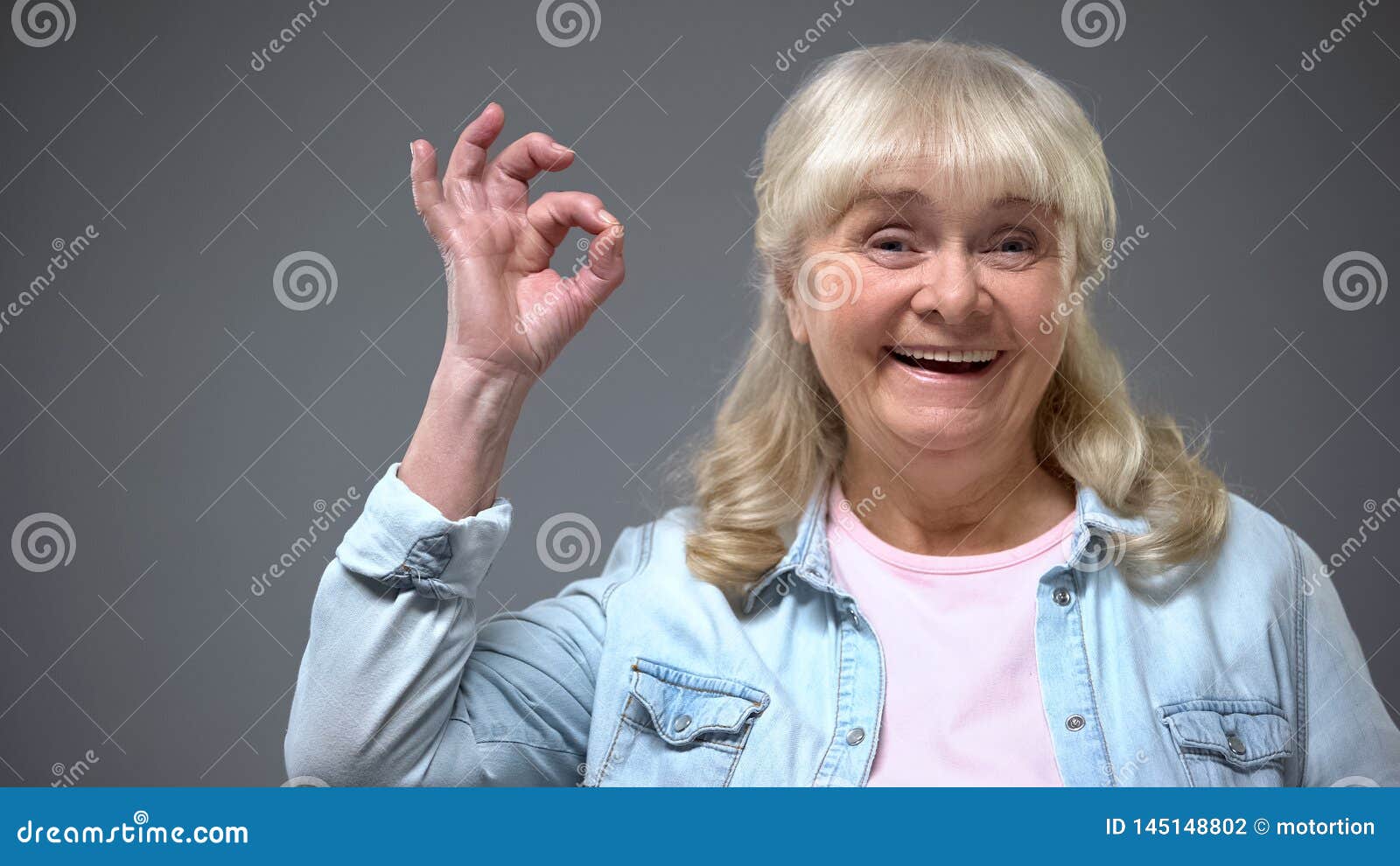 positive smiling aging female showing ok gesture, governmental aid approval