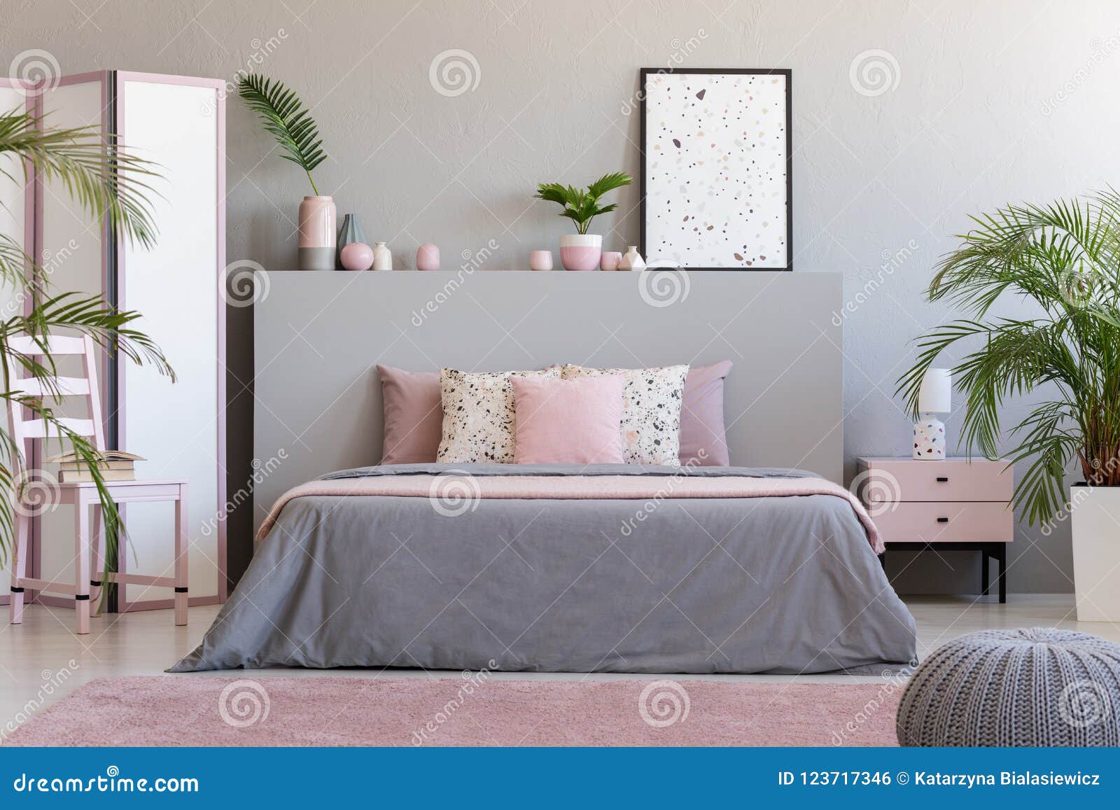 poster on grey bedhead in bedroom interior with pink pillows on