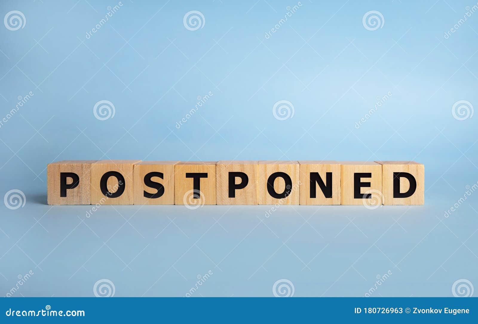 postponed - words from wooden blocks with letters, postponed concept, top view background