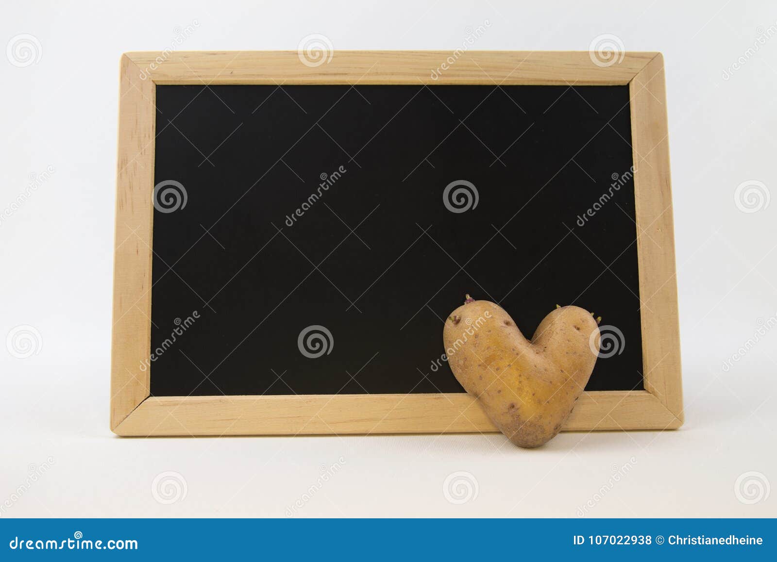 Potato Love Heart Shaped Potato in Front of a Blackboard Stock Photo