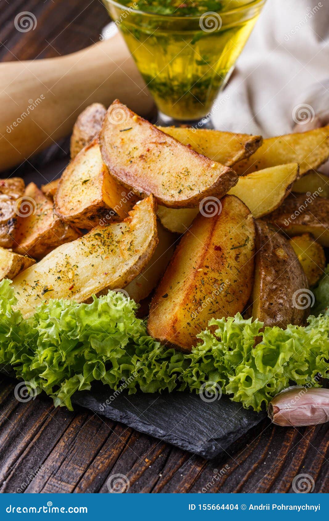 potato wedges baked in their skins with lettuce on wooden background