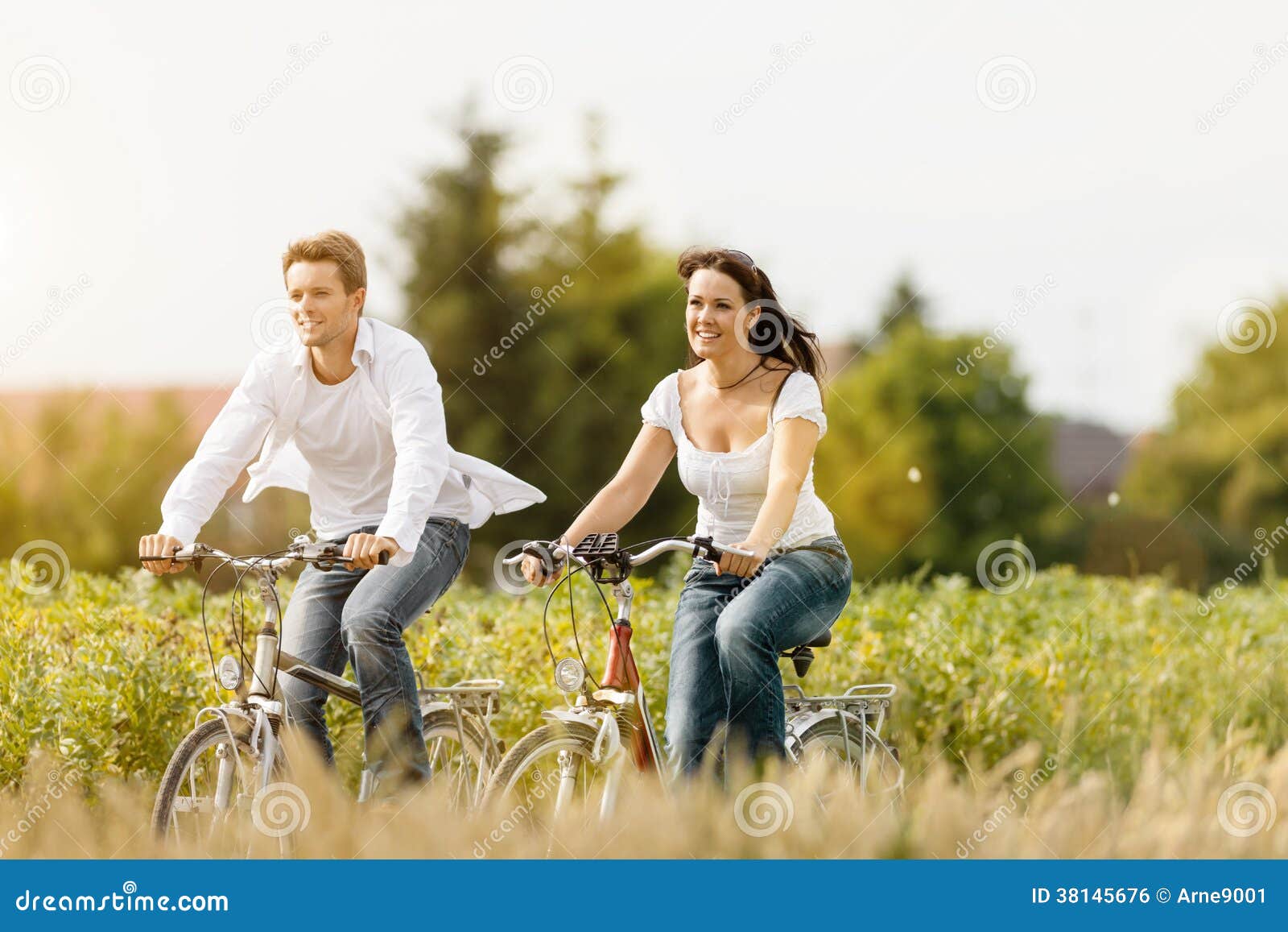 Potomstwo pary kolarstwo z bicyklem w lecie. Szczęśliwi potomstwa dobierają się kolarstwo z bicyklem w lecie w naturze, mężczyzna i kobiecie,