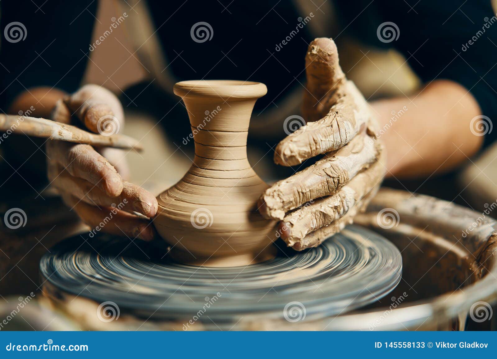 potter modeling ceramic pot from clay on a potter`s wheel