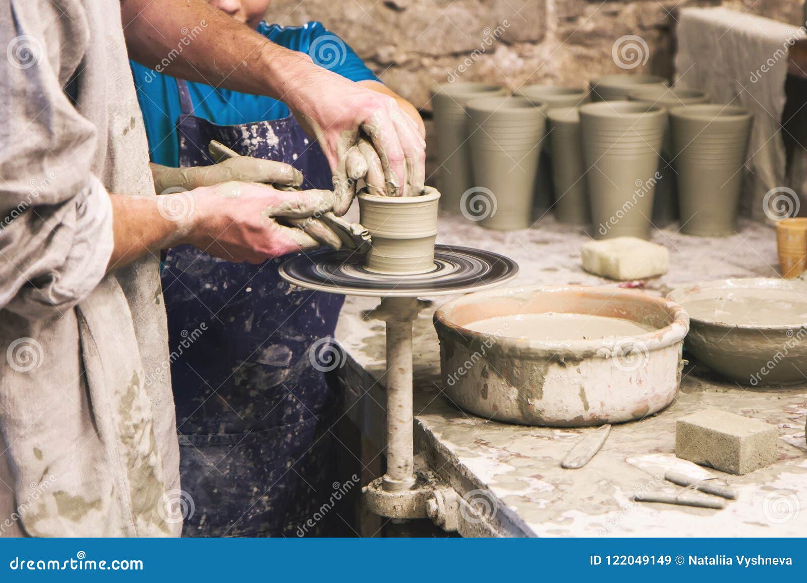 potter teaches to sculpt in clay pot on turning pottery wheel