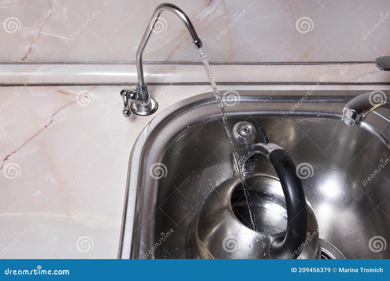 pouring filtered water into kettle from water filter. closeup of sink and faucet. drinkable water