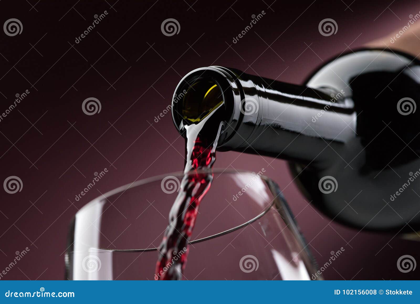 pouring red wine into a wineglass