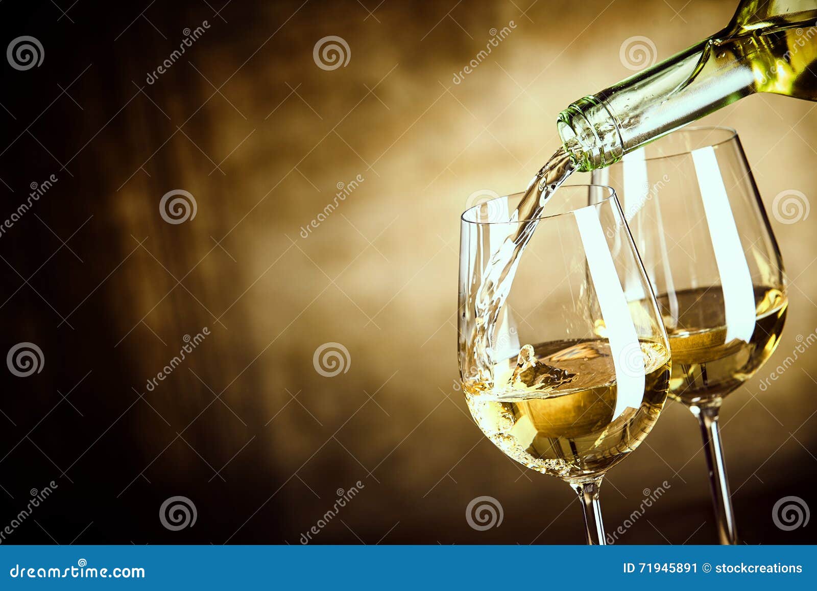 pouring two glasses of white wine from a bottle