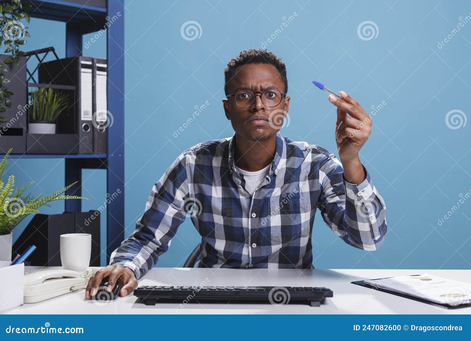 pov of unsure suspicious office administrator having pen in hand looking mistrustful at computer monitor.