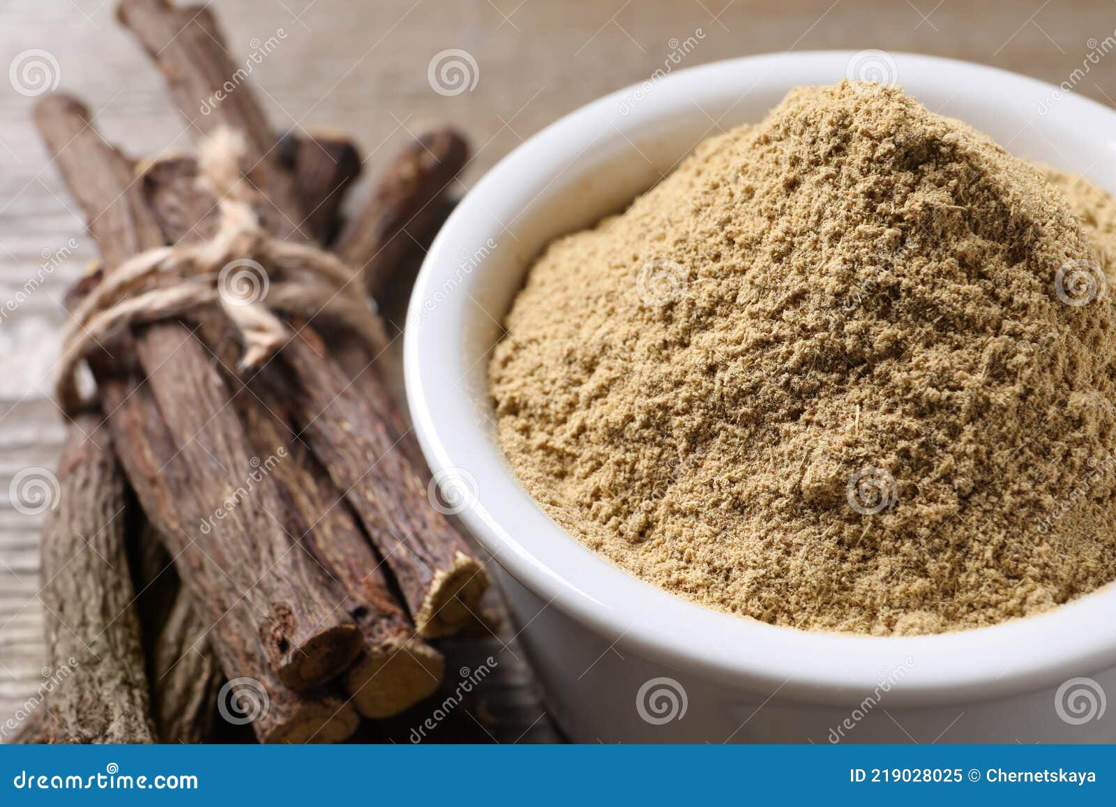 Powder in Bowl and Dried Sticks of Liquorice Root on Table, Closeup