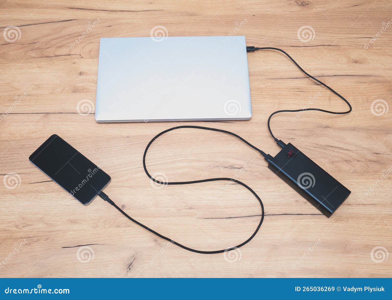 Power Bank with Usbc Cable is Charging Laptop and Smartphone. Modern