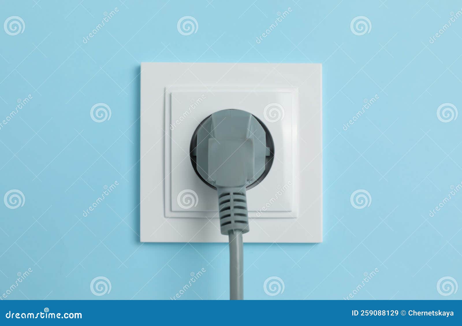 Power Socket with Inserted Plug on Light Blue Wall, Closeup. Electrical