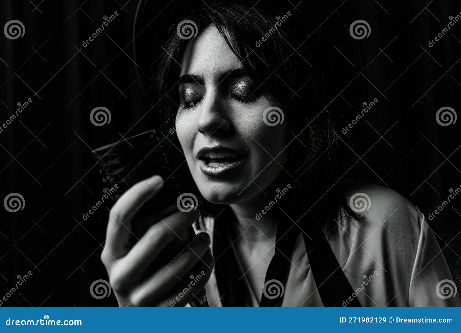 Emotional Close Up Black And White Photo Of Brunette Girl Singing Into Vintage Microphone Stock