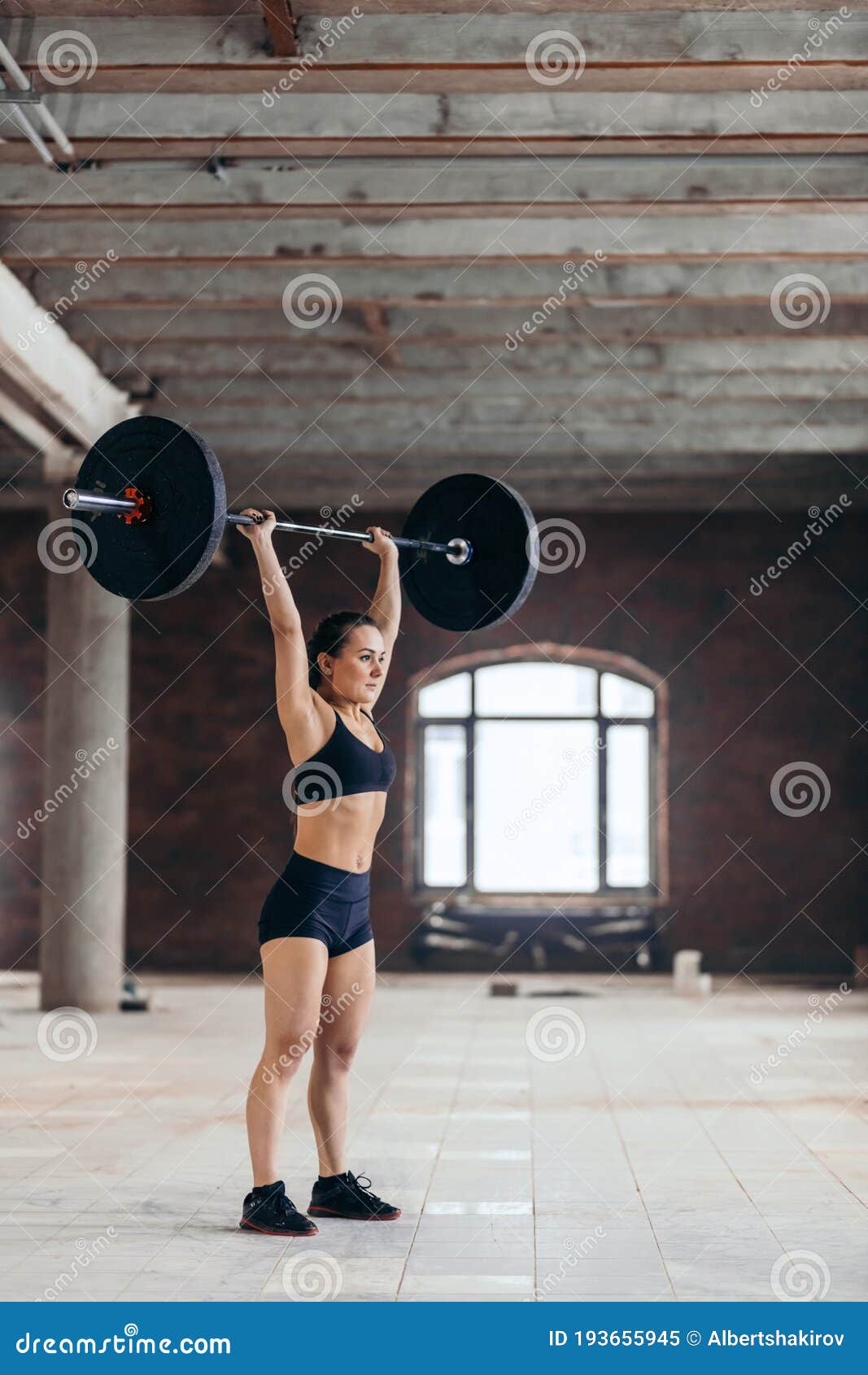 Powerful Girl Standing at Gym Lifting Heavybarbell Over Her Head Stock ...