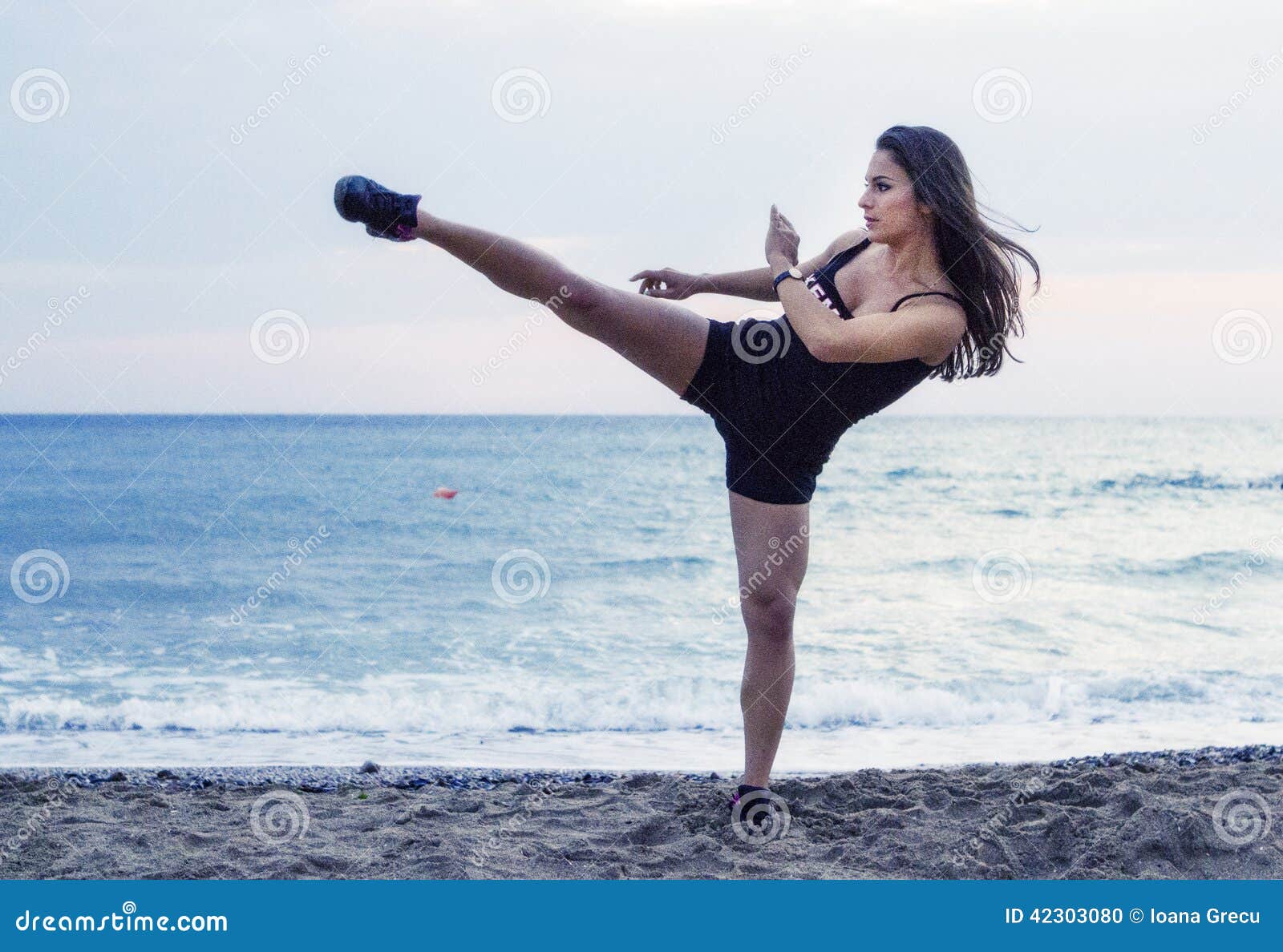powerful woman performing martial arts kick