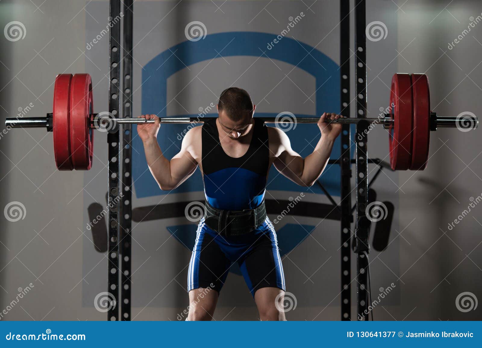 Powerlifter Using Barbell Exercising Legs Inside Gym Stock Image