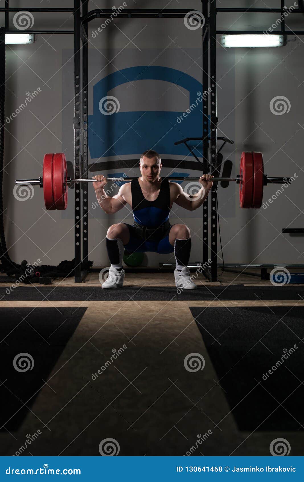 Powerlifter Using Barbell Exercising Legs Inside Gym Stock Photo