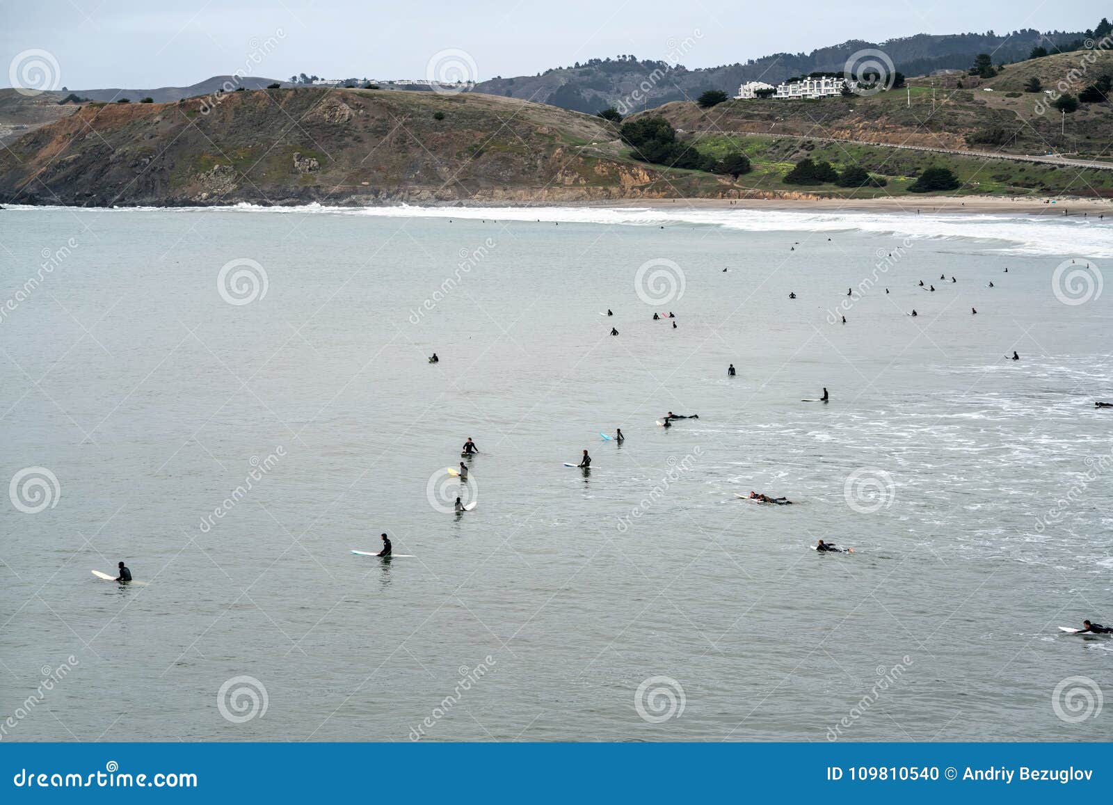 Praia de San Francisco. Muitos surfistas no oceano no fundo da praia, dos montes e do céu em San Francisco em Califórnia EUA horizontal