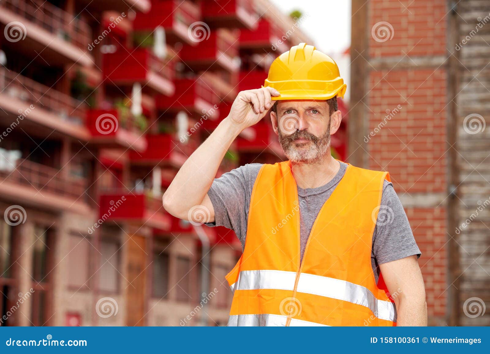 Bauarbeiter Mit Gelbem Sturzhelm Und Orange Weste Stockbild - Bild