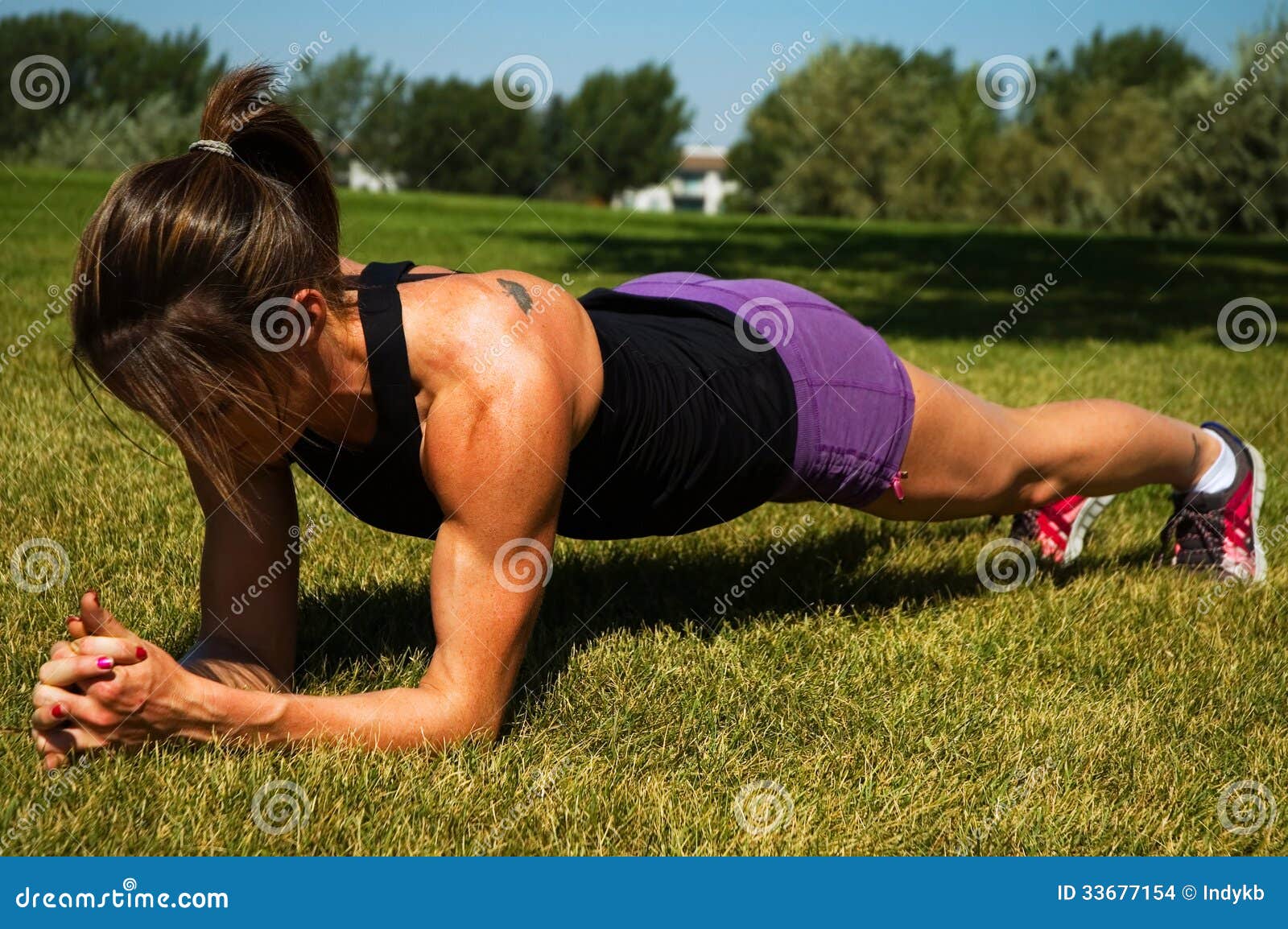 Mulher que faz a prancha em um parque da cidade.