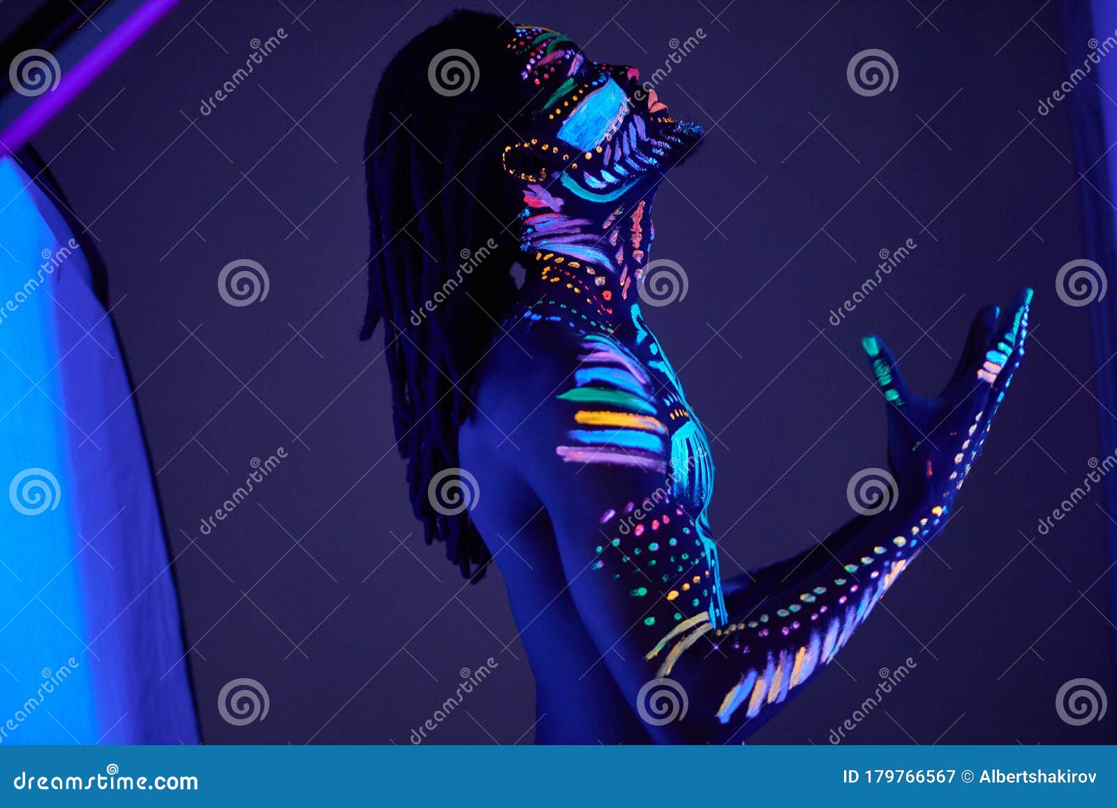 African prayer with UV body art glowing in darkness, colorful ethnic prints on naked skin. abstract fantastic futuristic paints, fluorescent make-up. man pray for the best