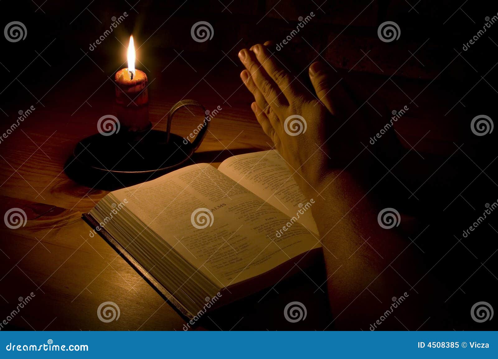 Praying by candle light stock image. Image of testament 4508385