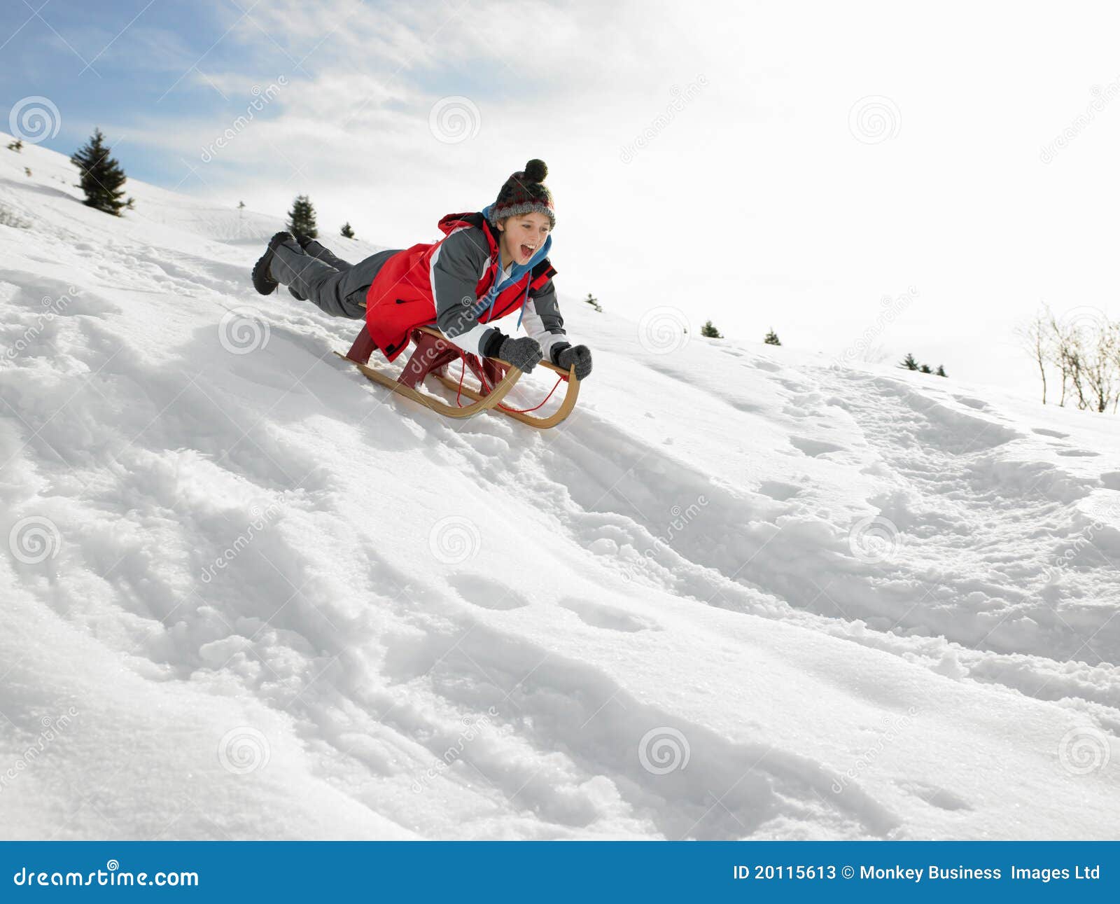 pre-teen boy on a sled in the snow