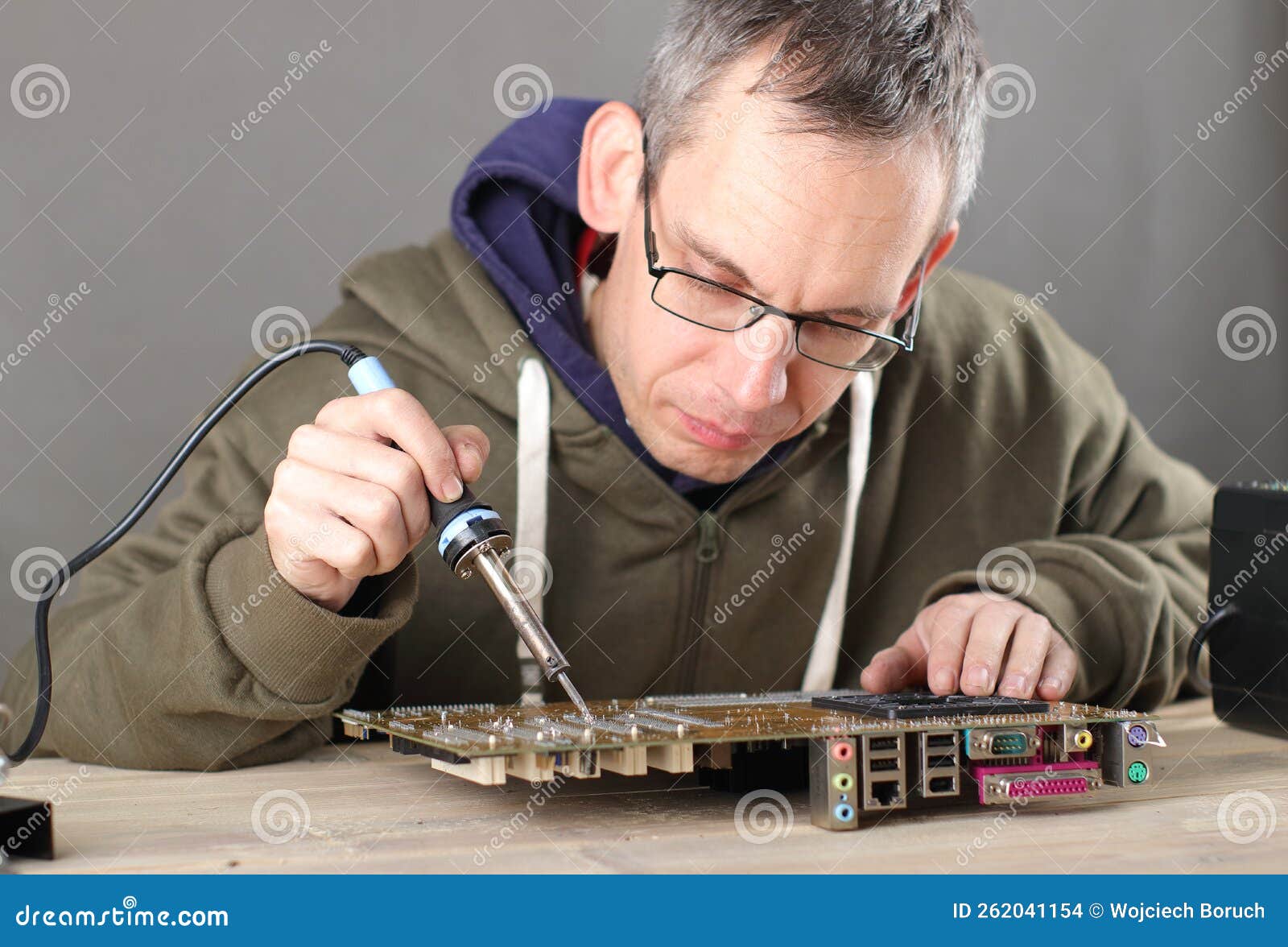 Precise Soldering of the Computer Motherboard on the Table Stock Photo