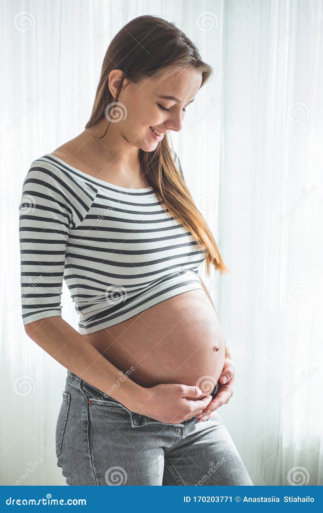 Happy Pregnant Woman with Big Belly by the Window. Concepts of