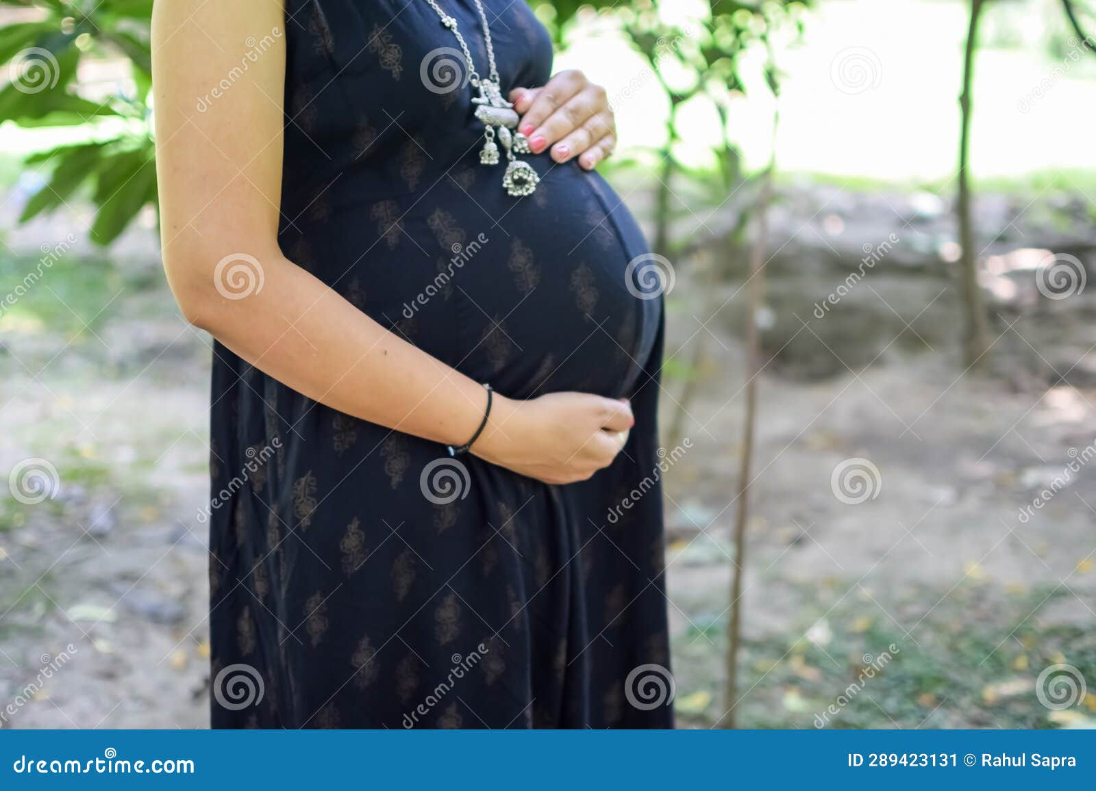 A Pregnant Indian Lady Poses for Outdoor Pregnancy Shoot and Hands on Belly,  Indian Pregnant Woman Puts Her Hand on Her Stomach Stock Image - Image of  adult, close: 289423131