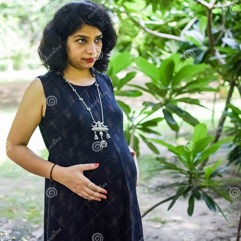 A Pregnant Indian Lady Poses For Outdoor Pregnancy Shoot And Hands On