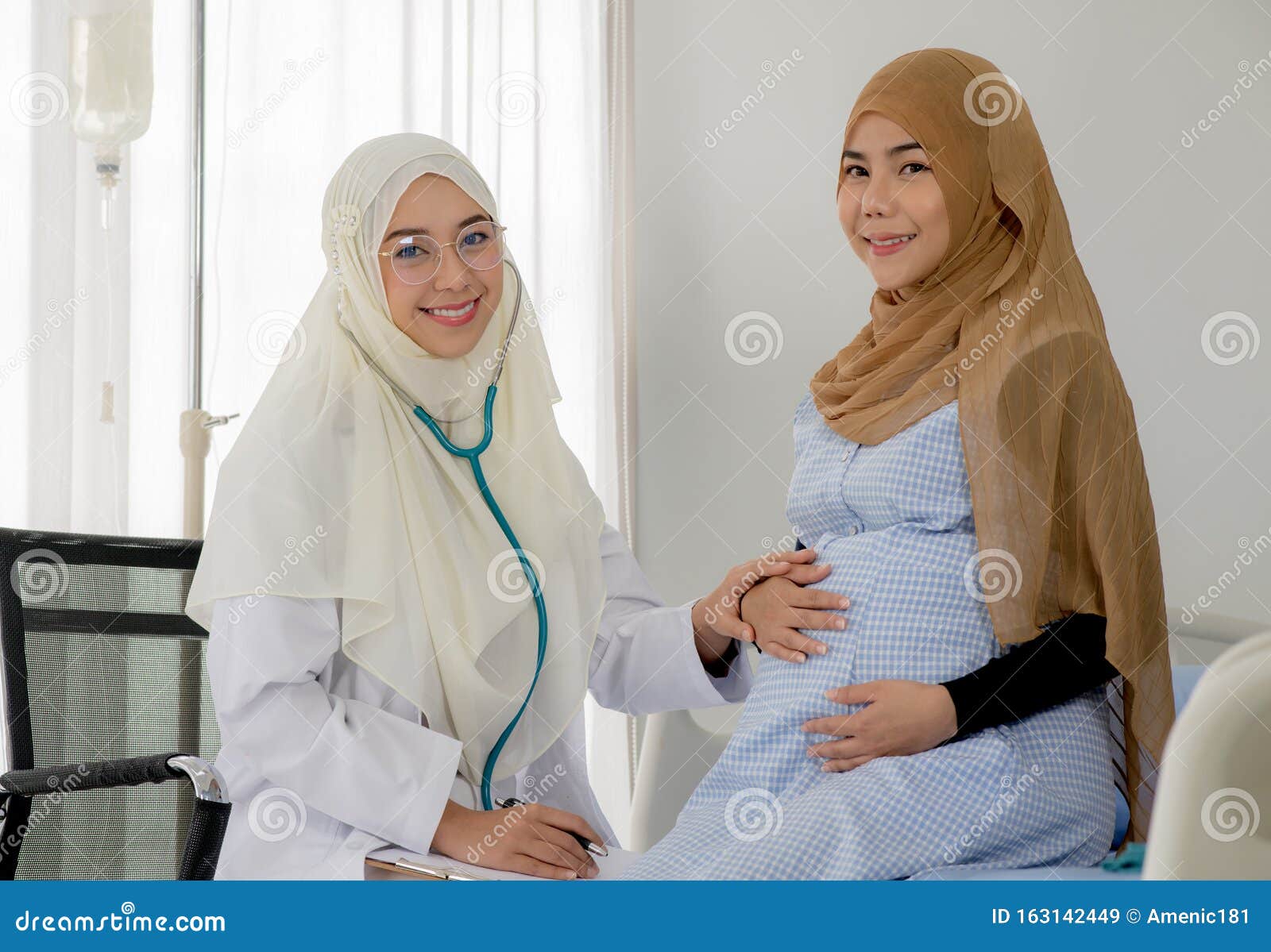 pregnant muslim woman with her muslim female doctor in clinic, gynaecology consultation