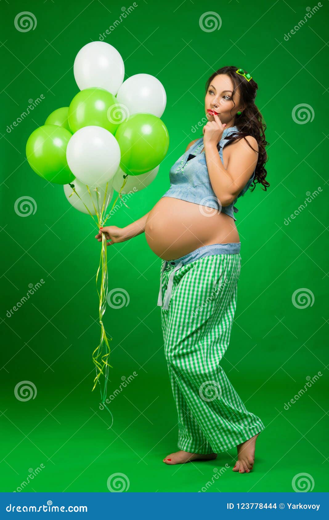 Pregnant Woman With Balloons On A Green Background He Looks At His Tummy In Anticipation Stock