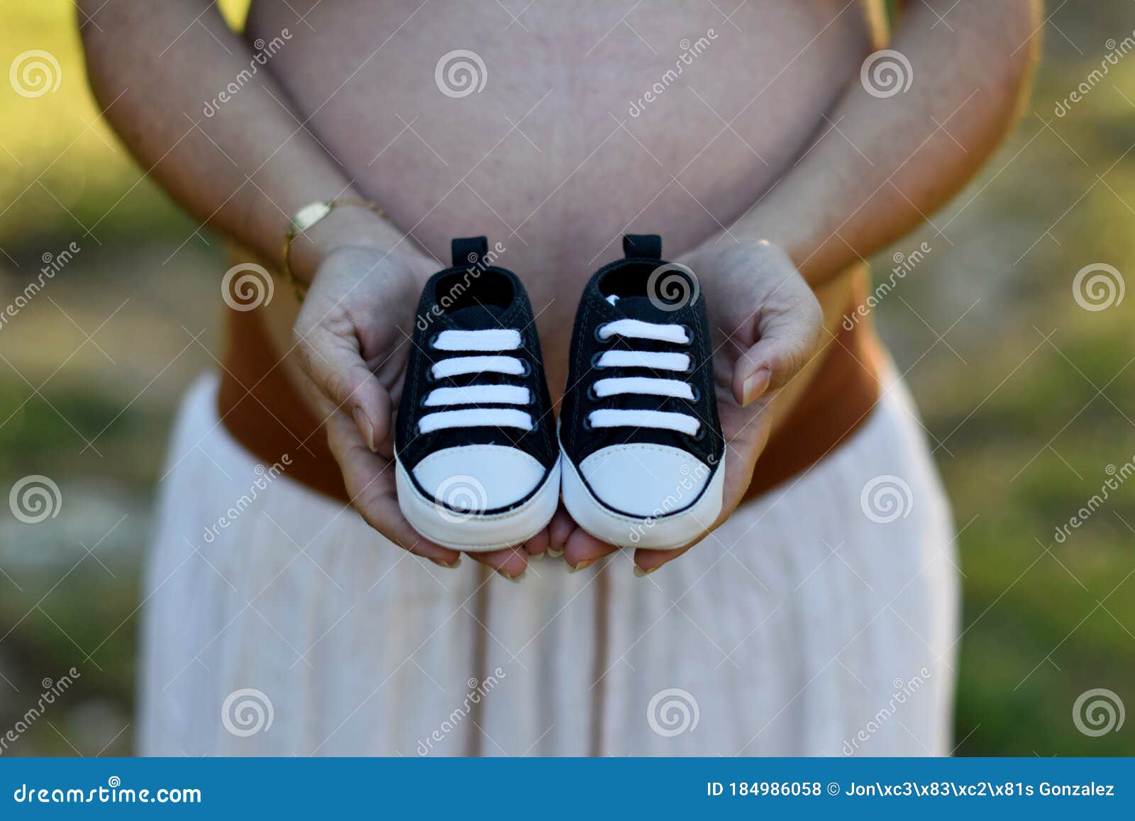 pregnant woman with child shoes in hands and on top of tummy