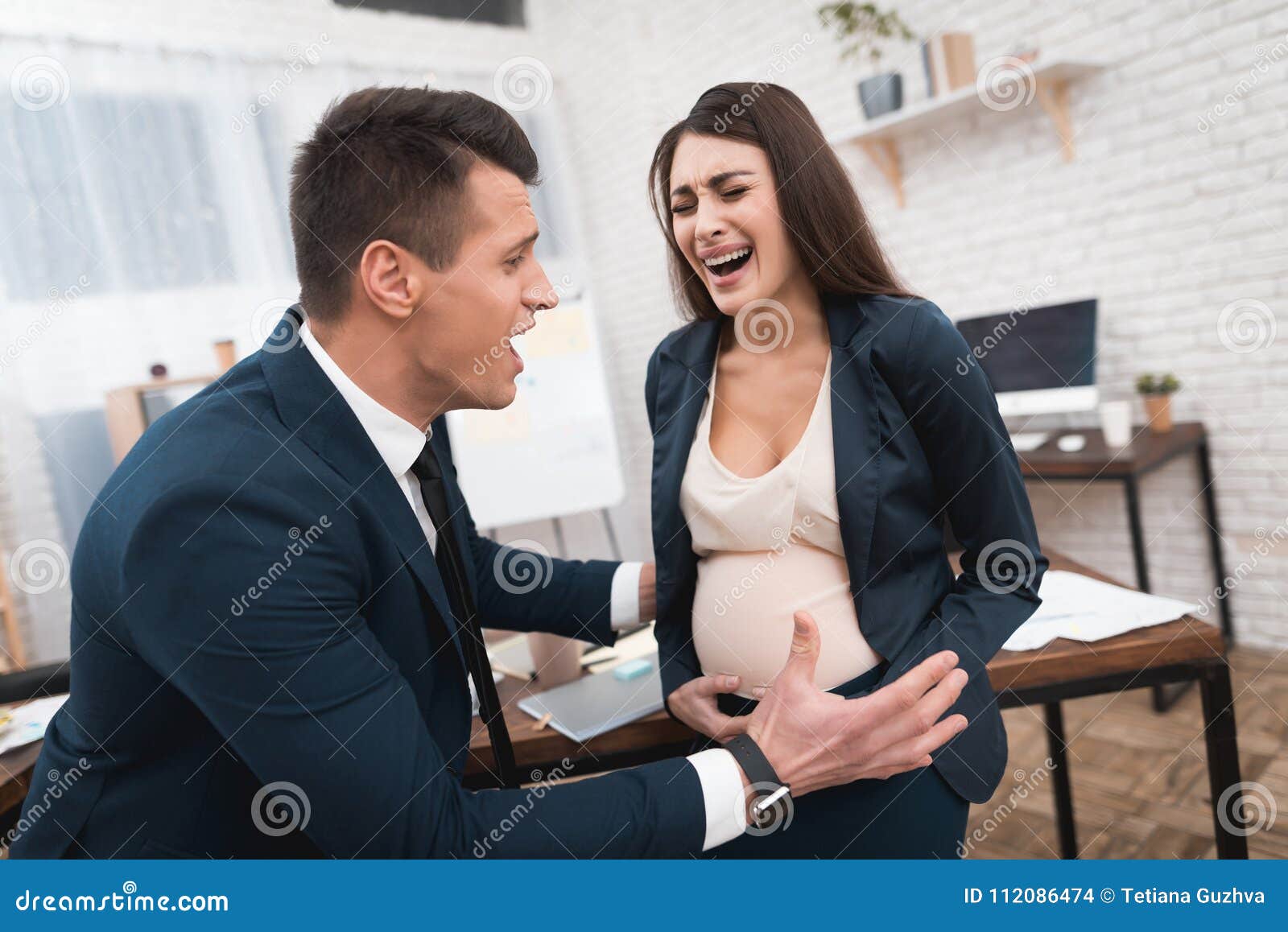 Pregnant Woman is Experiencing Labor in Office. Young Girl is ...